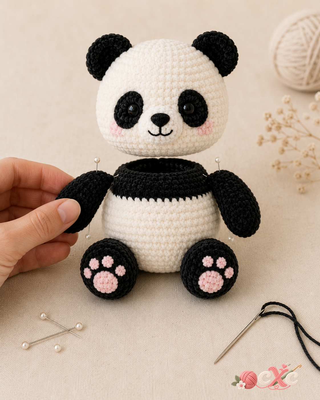 Crochet panda assembly with arms pinned to the body